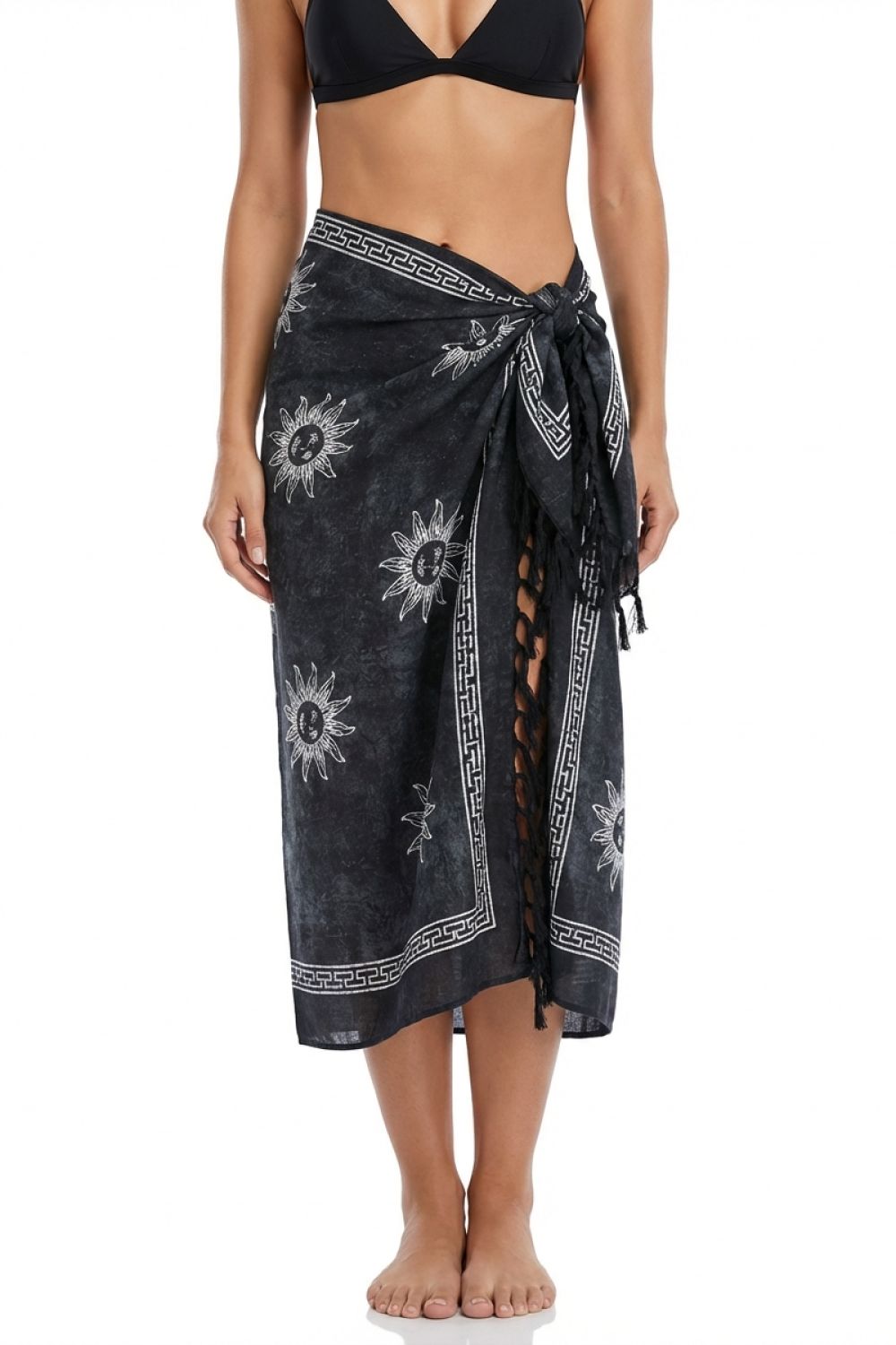 Person wearing a black patterned sarong over a black bikini top on a white background