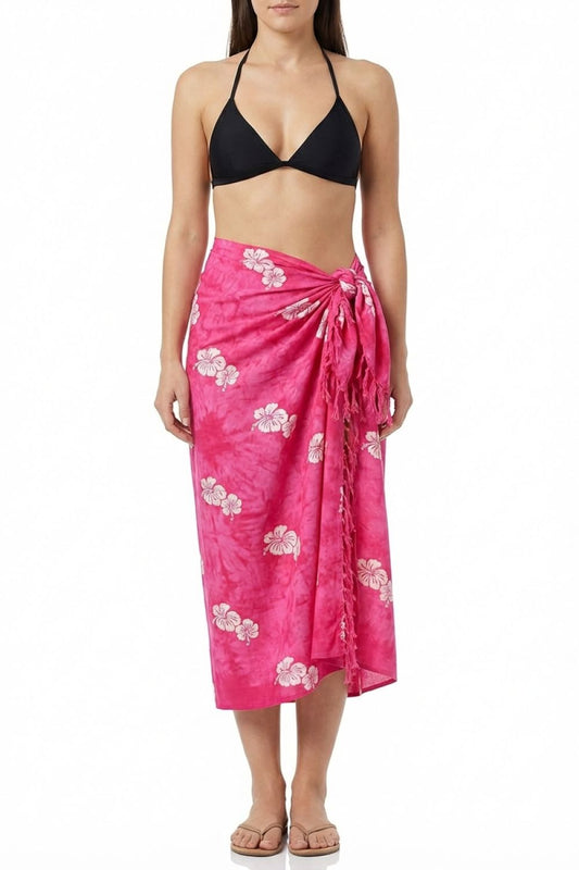 Woman wearing a black bikini top and pink floral sarong on a white background