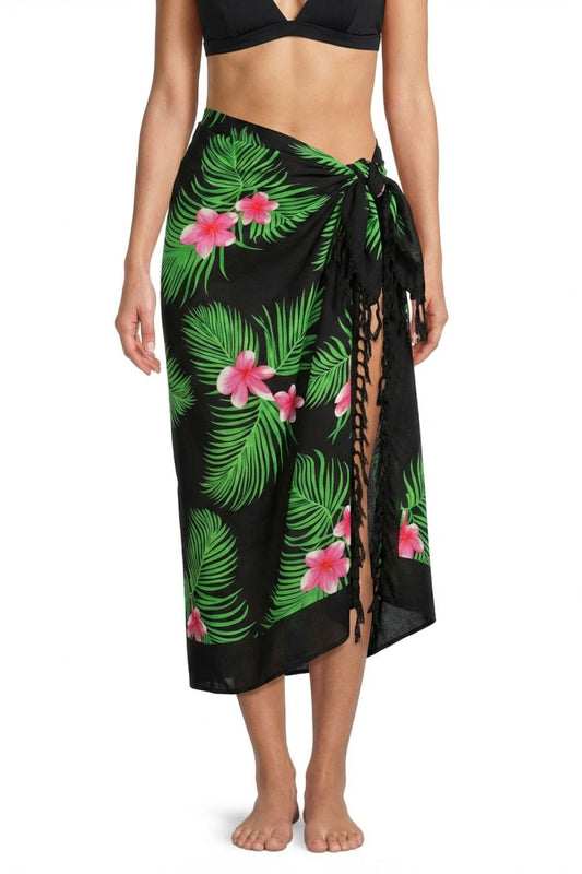 Woman wearing a black tropical print sarong with pink flowers on a white background