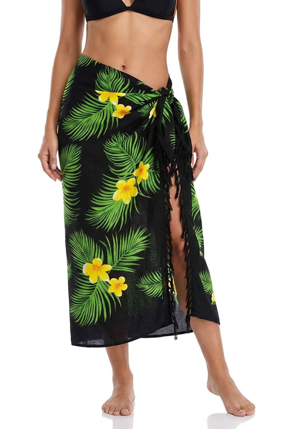 Black sarong with green leaf and yellow flower pattern worn by a person on a white background