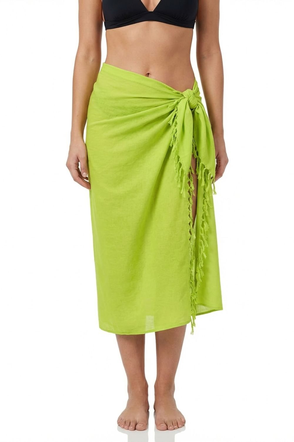 Person wearing a bright green sarong over black swimwear on a white background