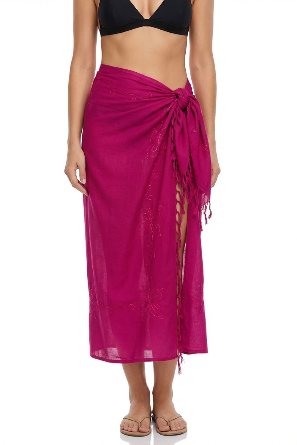 Person wearing a bright pink sarong over a black bikini top on a white background