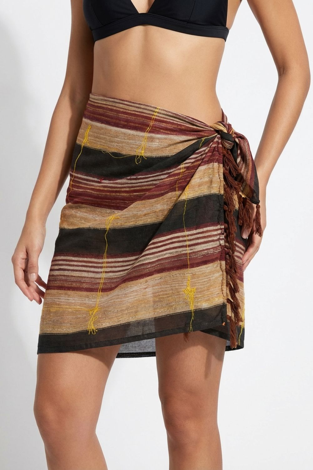 Woman wearing a striped sarong on a plain background