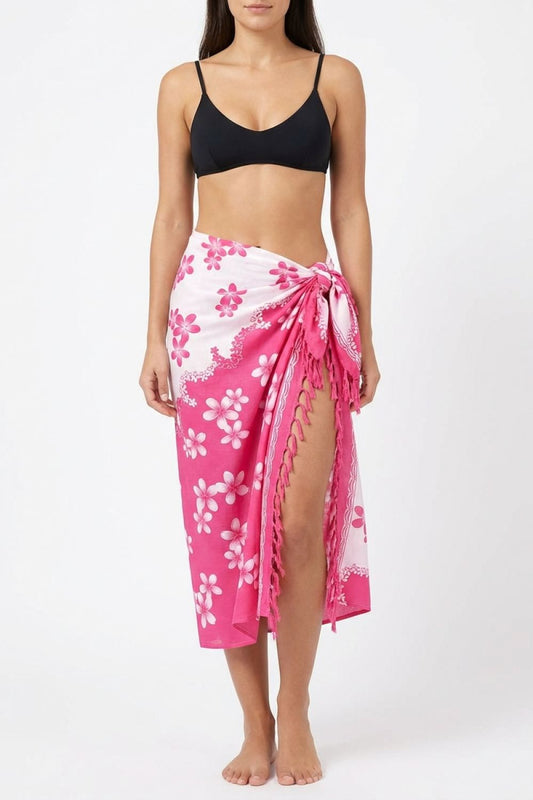 Woman wearing a black bikini top and pink floral sarong on a white background