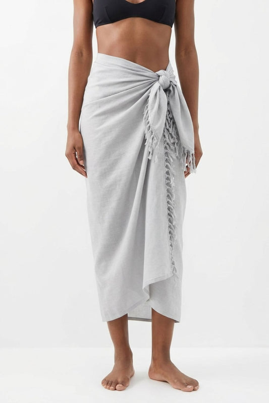 Person wearing a light gray sarong on a white background