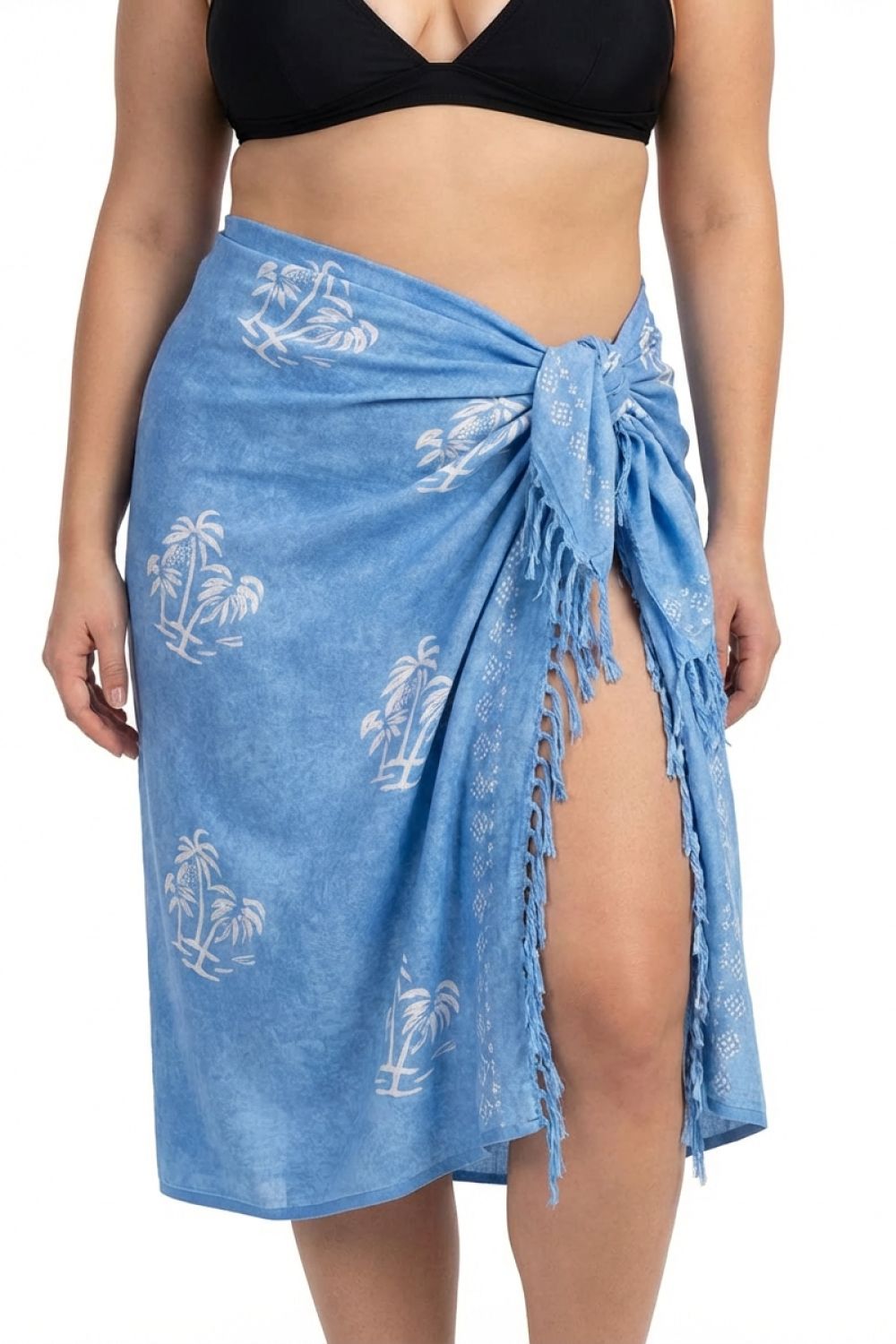 Woman wearing a blue sarong with palm tree patterns on a white background