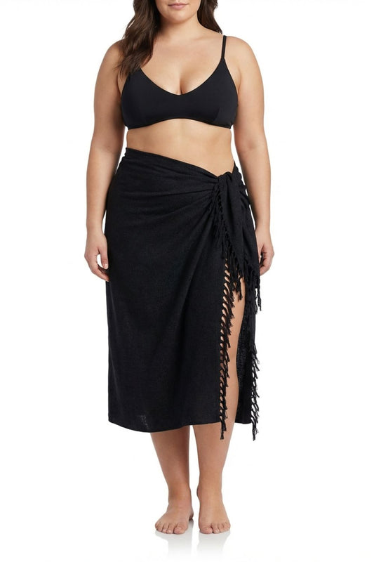 Woman wearing a black bikini with a matching black sarong on a white background