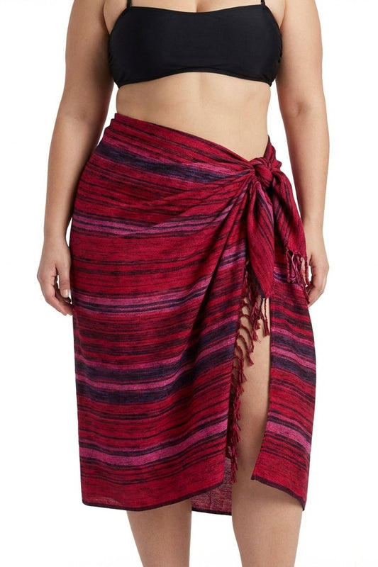 Woman wearing a black bikini top and red striped sarong on a white background