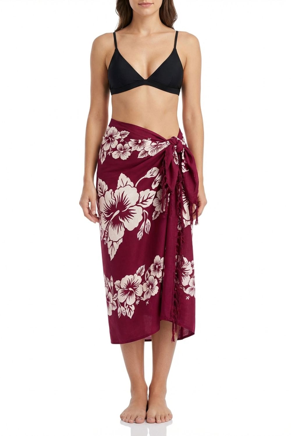 Woman wearing a black bikini top and burgundy floral sarong on a white background