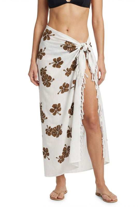 Woman wearing a white sarong with brown floral patterns on a white background