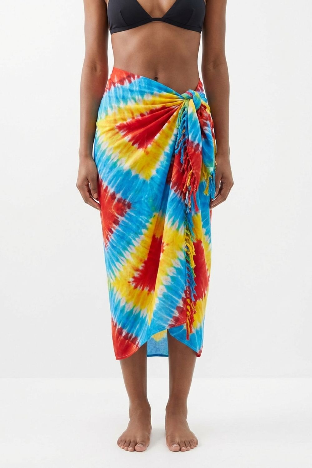 Person wearing a colorful tie-dye sarong on a white background